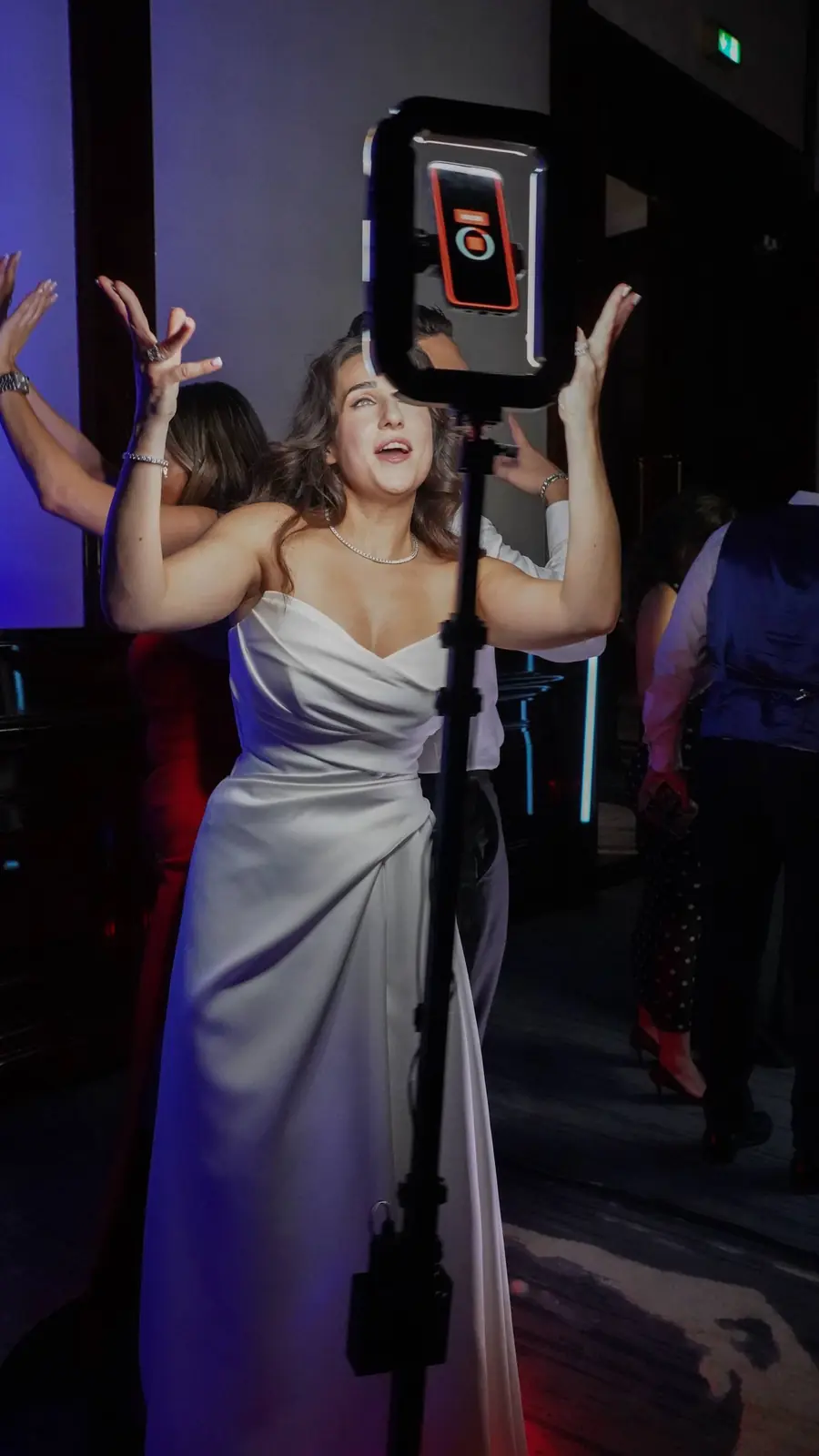 A guest in a white gown posing at a ring-light 360° camera