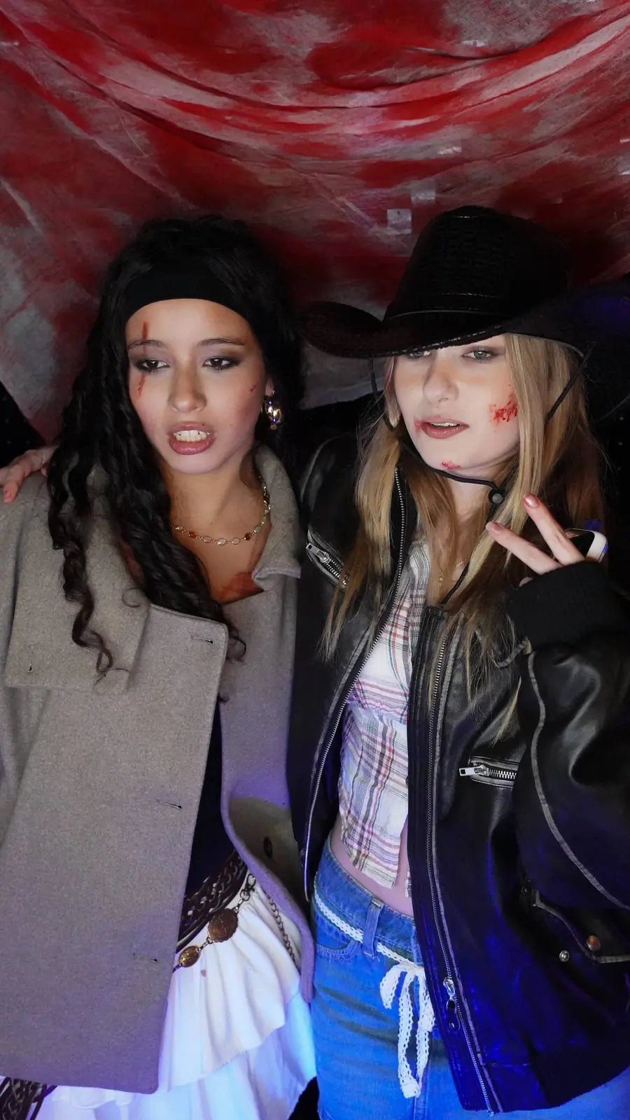 Two guests in Halloween costumes posing for a close booth portrait